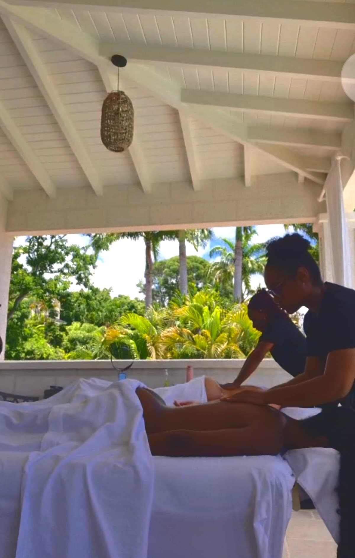 TUTCH Mobile Spa Barbados – therapists giving a massage on a tropical terrace overlooking palm trees